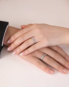 two people with wedding rings on their hands, one holding the other's hand