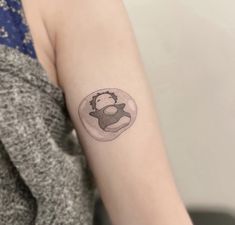 a woman's arm with a small tattoo of a deer in a glass ball