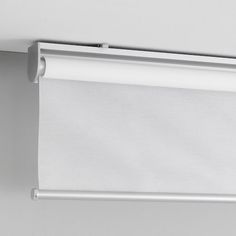 a white roller shade hanging on the side of a wall