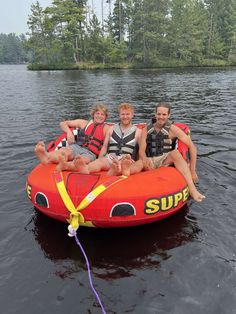 three people are sitting on an inflatable boat