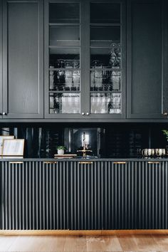 a kitchen with black cabinets and gold trim