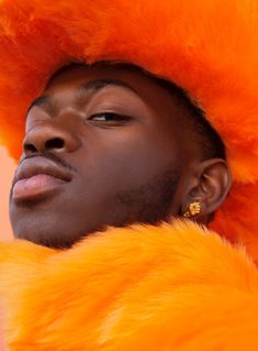 a man wearing an orange fur hat