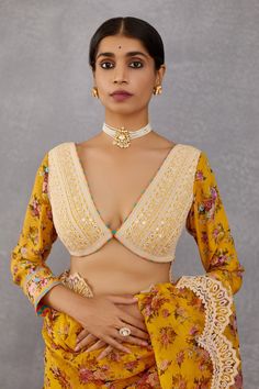 Topaz yellow saree blouse with placement floral motifs, embroidered detail and plunging neck.
Component: 1
Embroidered, Printed
Neckline: V Neck
Sleeve Length: Full
Fabric: Handwoven Chanderi, cotton silk
Color: Yellow
Plunging neck
Tassel tie-up back
Cuff sleeves
Note: Saree and head scarf worn by the model is not for sale
 - Aza Fashions Semi-stitched Embroidered V-neck Blouse Piece, Designer V-neck Choli With Resham Embroidery, V-neck Wedding Blouse With Intricate Embroidery, Festive V-neck Embroidered Top For Wedding, Wedding V-neck Blouse With Intricate Embroidery, Yellow Georgette Choli With Chikankari Embroidery, Bollywood V-neck Blouse With Resham Embroidery, Yellow Choli With Chikankari Embroidery, Yellow Long Sleeve Top With Resham Embroidery