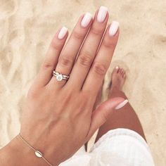 a woman's hand with white manicures and a ring