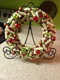 a christmas wreath made out of wine corks on a kitchen counter next to an oven