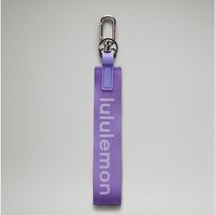 a purple keychain with the word mennon on it, hanging from a metal hook