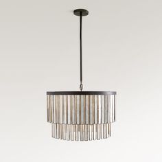 a chandelier hanging from the ceiling with metal strips on it and a round light fixture