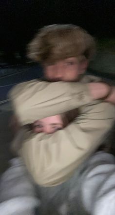 a blurry image of a man hugging another man's head with his arms around him