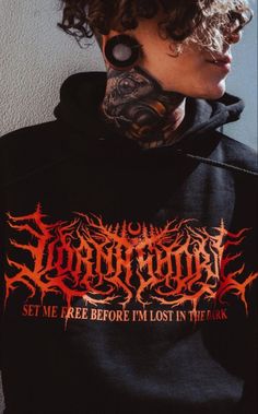 a woman with tattoos and piercings on her face is wearing a black hoodie