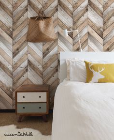 a bed room with a neatly made bed next to a wooden wallpaper self ad