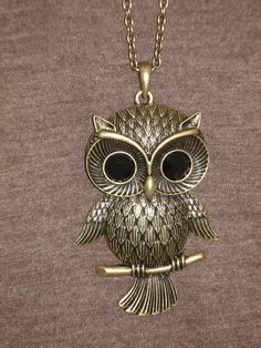 an owl necklace is shown on a mannequin