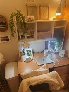 a laptop computer sitting on top of a wooden desk next to a lamp and chair