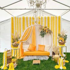 an outdoor tent decorated with yellow and white decor