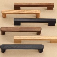 four different types of wooden furniture on a beige surface with black and brown handles, all in various shapes and sizes