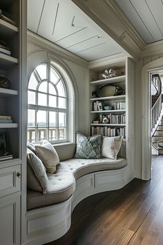 a window seat in the corner of a room with bookshelves and shelves on either side