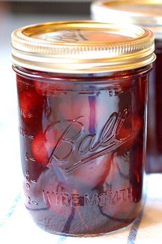 two jars filled with jelly sitting on top of a table