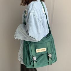 Upgrade your everyday carry with our Japanese Simple Messenger Bag. Made with high-quality materials and featuring a sleek design, this handbag is perfect for those who want both style and functionality. CLASSIC STYLE - Great for everyday use, school, college, basics, and travel accessories. CUTE ACCESSORY - It comes with an adorable removable green frog that will accompany you at all times. ROOMY - Features an extra large main compartment and front pocket, big enough for a 14 inch laptop. UPGRA Korean Bag, Korean Student, Waterproof Crossbody Bag, Postman Bag, Tas Fashion, Student Bag, Casual Tote, Shoulder Messenger Bag, 가을 패션