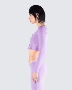 Make any look 10x sweeter with this purple rib long sleeved top 😊 Constructed from fine stretch rib fabric, adorned with delicate lace and rosette flower trim, this piece boasts a flattering scoop neck, an empire waist, and a stylish peplum design with a fly-away hem 💜 Chic Fitted Long Sleeve Top For Loungewear, Purple Stretch Feminine Top, Stretch Purple Feminine Tops, Feminine Fitted Purple Tops, Feminine Fitted Lavender Top, Lavender Fitted Long Sleeve Top, Flyaway Top, Rosette Flower, Peplum Design