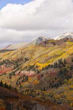 the mountains are covered in fall colored trees