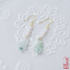 "This pair of dangle earrings features cute gourd-shaped jade pendants, paired with freshwater pearl beads. The bottle gourd is called \"Hu-Lu\"(葫蘆) in Chinese, the homophony of \"Fu-Lu\"(福祿), and means good luck and wealth in Chinese culture. The pearl is a symbol of health, longevity and wealth. So these earrings express lots of blessings. 🌷Item Specifics ❊ Jade Beads ❊ Freshwater Pearl Beads ❊ Gold-Plated Brass Findings ❊ Gold-Plated Silver Hooks ❊ Length: about 2 in. 🌷Our Collection ❊ See Bottle Gourd, Gold Pearl Jewelry, Chinese Jade, Jade Beads, Jade Pendant, Etsy Earrings Dangle, Chinese Culture, The Pearl, Gold Pearl