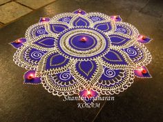 a purple and white circular design on the ground with candles lit up in front of it