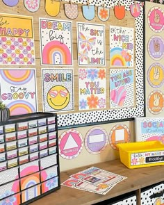 a bulletin board with lots of pictures on it and some bins in front of it