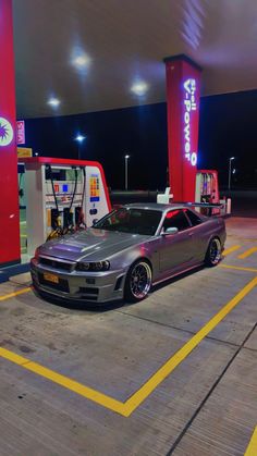 a silver car parked in front of a gas station