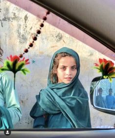 two women are standing in front of a rear view mirror