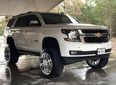 a white chevy suburban truck parked in a garage