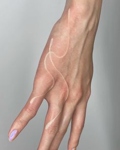 a woman's hand with white lines painted on it