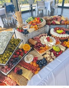 a table topped with lots of different types of food on top of a white table cloth