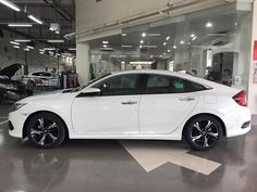 a white car is parked in a showroom