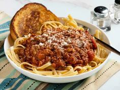 a bowl of spaghetti with bread on the side