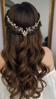 a woman with long brown hair wearing a gold leaf headpiece in front of a mirror