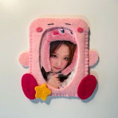 a girl is holding a spoon in front of a pink car shaped magnet with a star on it