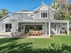 a house that is sitting in the grass with a table and chairs on top of it