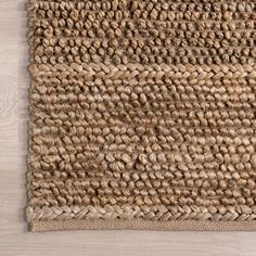 an area rug made out of jute on a wooden floor