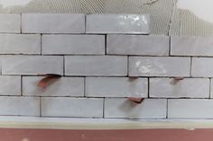 a white brick wall that has been torn apart