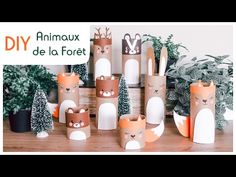 several different types of paper animals on a table next to plants and potted trees