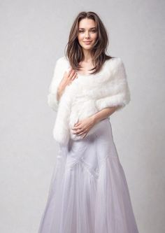 a woman in a white dress and fur stole