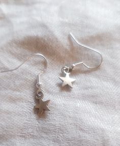 "Simple silver star earrings.  (Hypoallergenic silver plated hooks) 1 1/8\" in drop length If you are outside of the US and would like to purchase this listing, please message me with your location so I can list an accurate shipping price. And for any other questions, feel free to contact me and I will respond ASAP" Handmade Dainty Star Earrings, Silver Adjustable Star Earrings, Star-shaped Earrings With Lever Back For Gifts, Adjustable Sterling Silver Earrings With Star Charm, Silver Star-shaped Earrings With Ear Wire, Silver Star-shaped Earrings, Dainty Silver Star Earrings, Hypoallergenic Sterling Silver Star Earrings, Silver Star Charm Earrings For Everyday