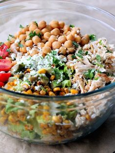 a glass bowl filled with salad and chickpeas