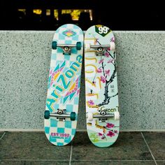 two skateboards are leaning against a wall