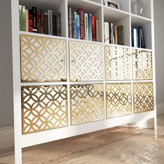 a white bookcase with gold laser cutouts and bookshelves in the background