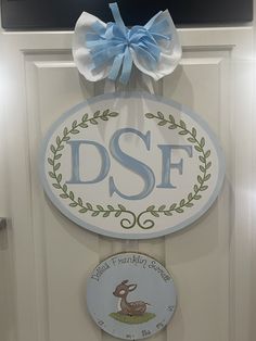 a door hanger with a blue bow on it's head and the word dsf