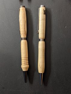 two small wooden objects on a black surface