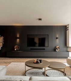 a living room with couches, tables and a flat screen tv on the wall