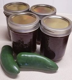 four jars of pickles and two green peppers