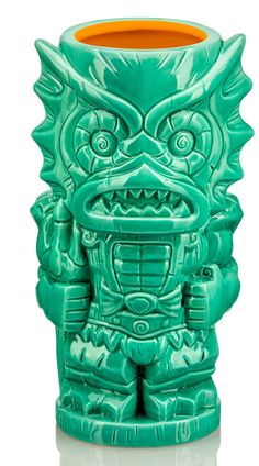 a green ceramic vase with an angry face on it