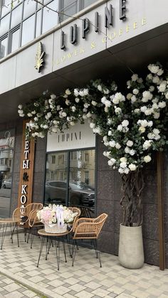 the outside of a coffee shop with tables and chairs